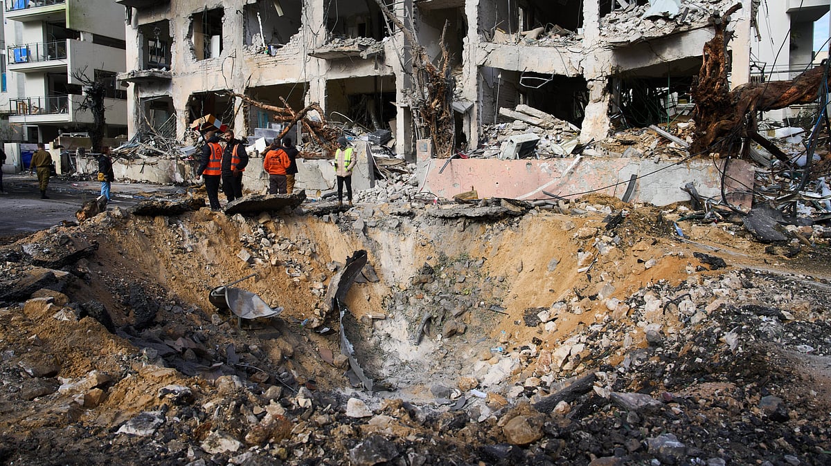 Rescue teams and military personnel survey the site of an Iranian missile impact in Tel Aviv.