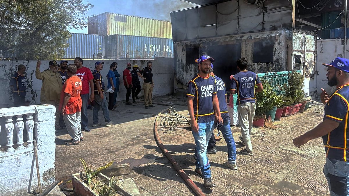 Police inspect a burnt post set ablaze by protesters near the US Consulate in Karachi.