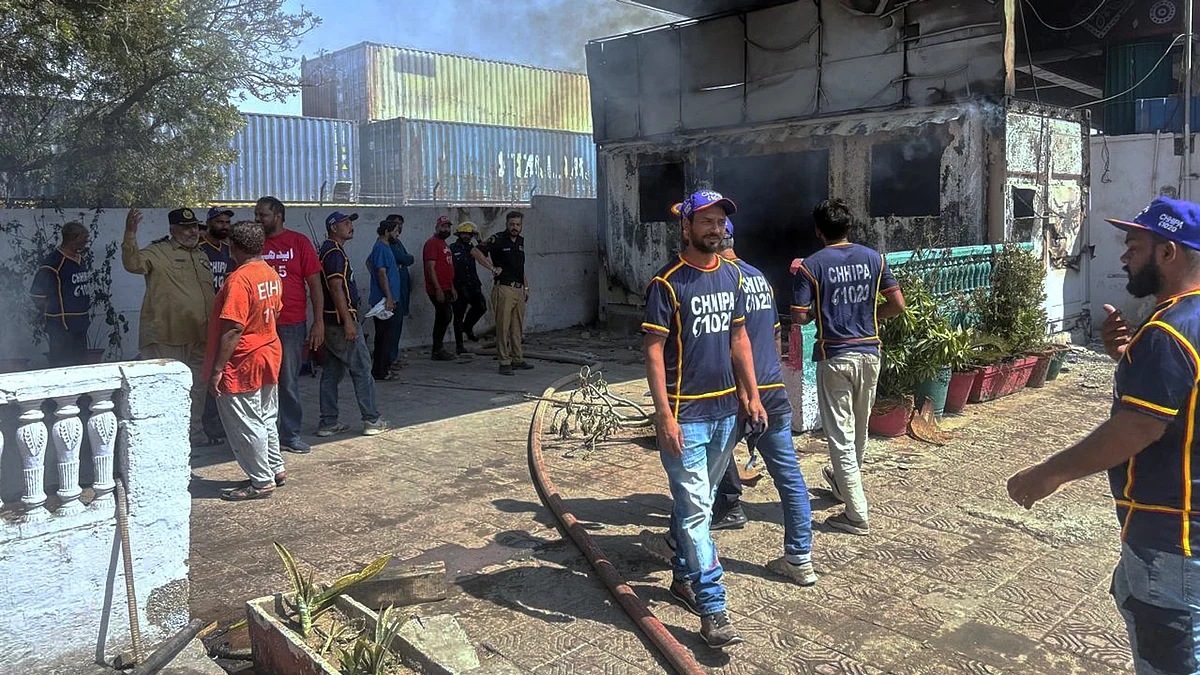 Police inspect a burnt post set ablaze by protesters near the US Consulate in Karachi.