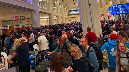 Stranded passengers wait anxiously at a airport after sudden flight cancellations.