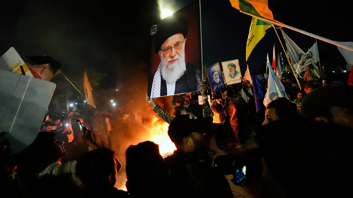 Shiite Muslims hold a portrait of the late Ayatollah Ali Khamenei in Baghdad, Iraq, 13 March