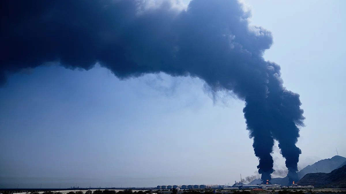 Smoke rises from the debris of an intercepted Iranian drone at an oil facility in Fujairah, UAE, 14 March