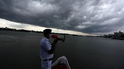 Cop sounds alert along the Ganges in Kolkata.