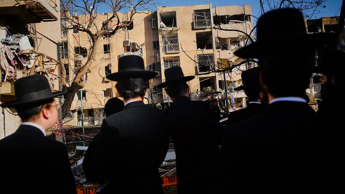 Residents view buildings damaged by an Iranian missile strike in Arad, southern Israel, 22 March