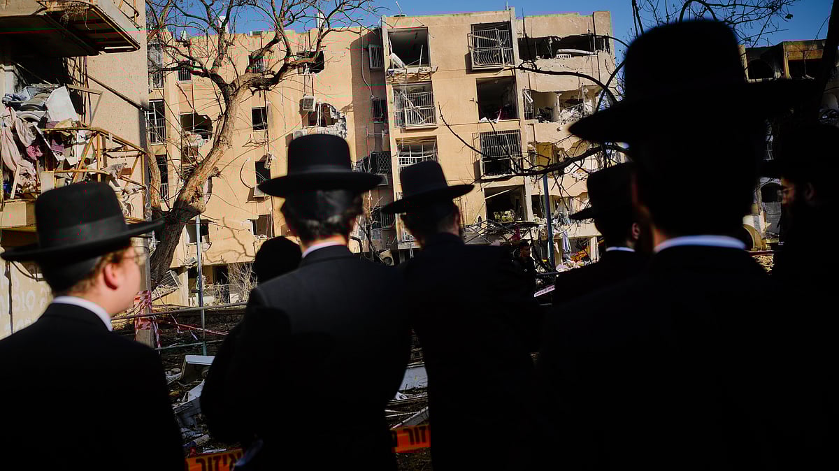 Residents view buildings damaged by an Iranian missile strike in Arad, southern Israel, 22 March