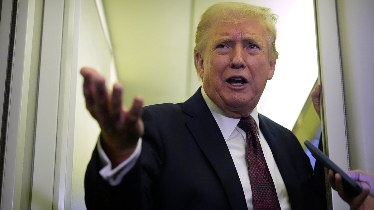 Donald Trump speaks to reporters aboard Air Force One (file photo)