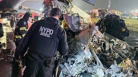 Officials survey the crash site as investigators begin probing the deadly runway collision.