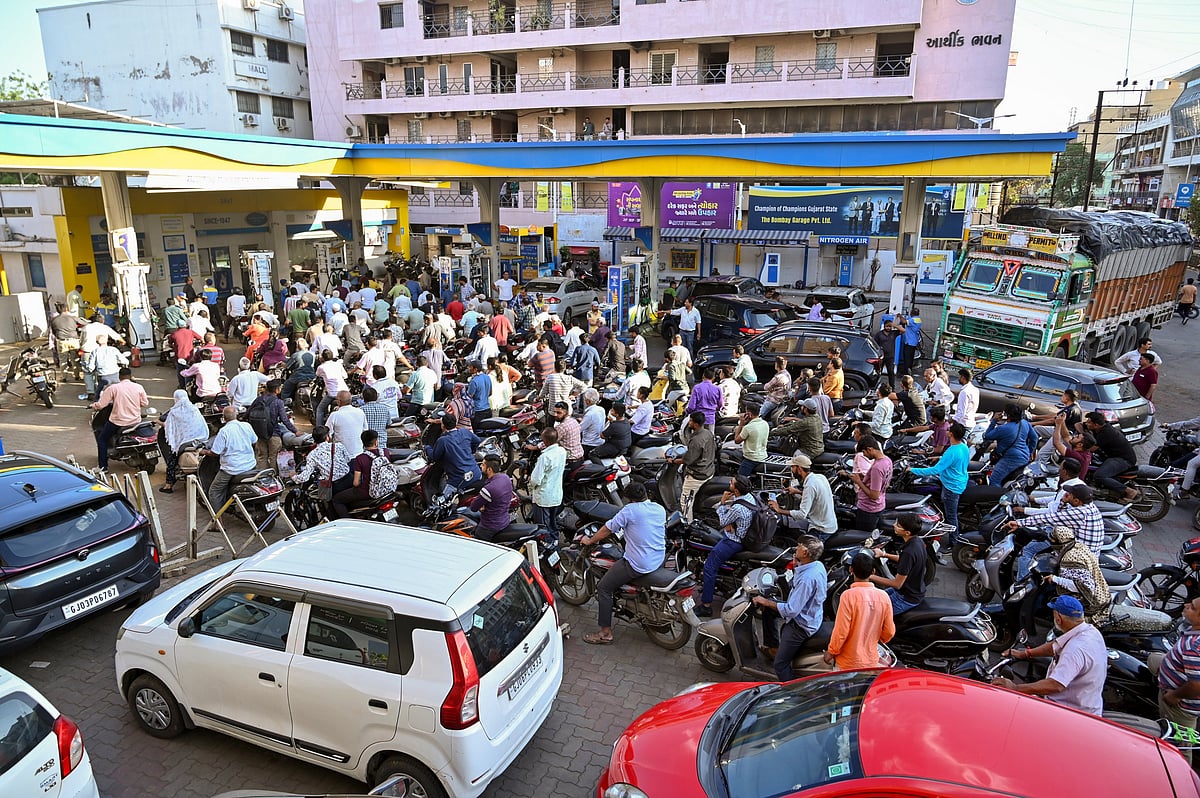 People queue up at a petrol station in Rajkot, Gujarat