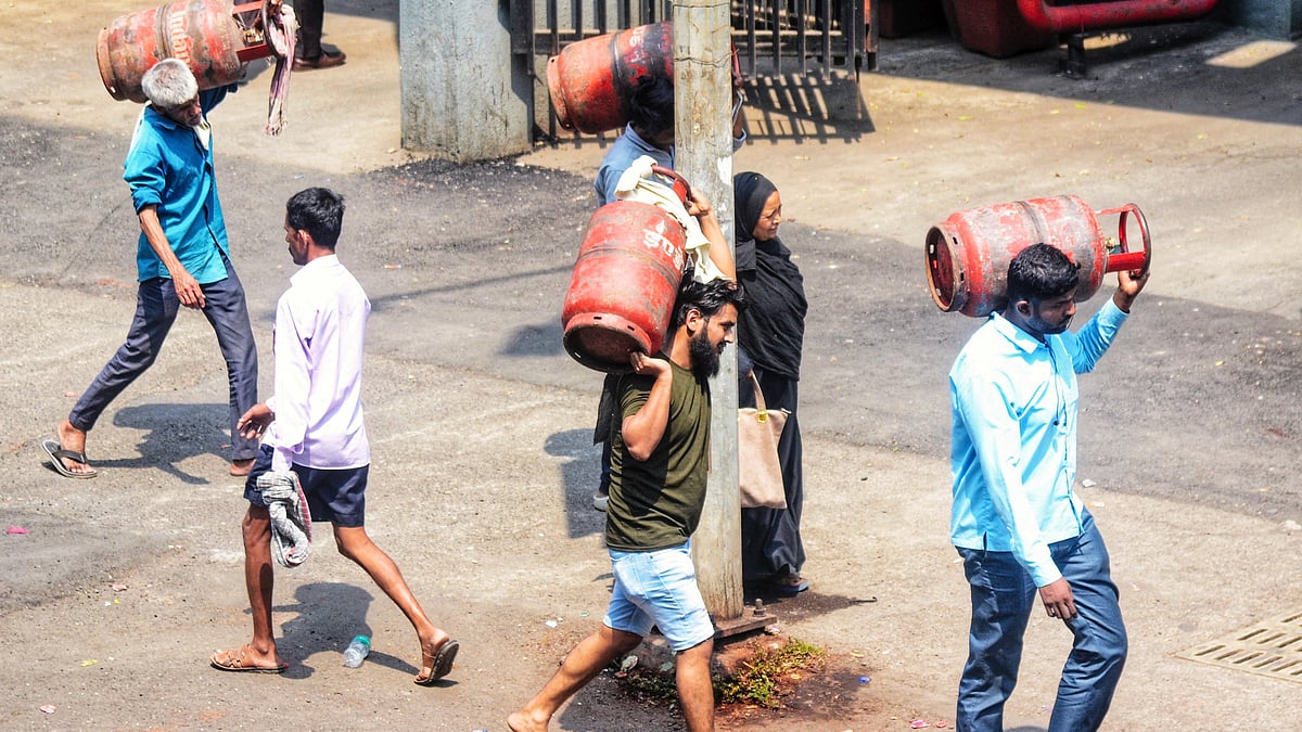 People carry empty LPG cylinders to a gas agency at Sanpada, Navi Mumbai, 25 March