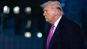 Donald Trump walks across the South Lawn upon arrival at the White House.