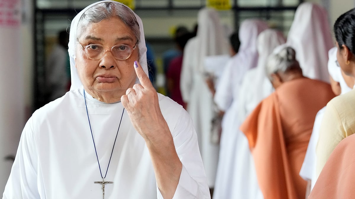 A nun shows her ink-marked finger after casting vote during Puducherry Assembly elections.