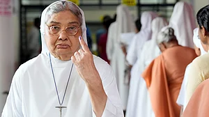 A nun shows her ink-marked finger after casting vote during Puducherry Assembly elections.