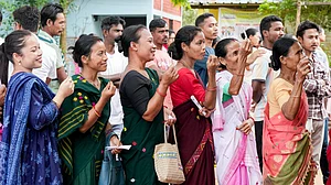 People wait in a queue to cast their votes in Assam's Kamrup district.