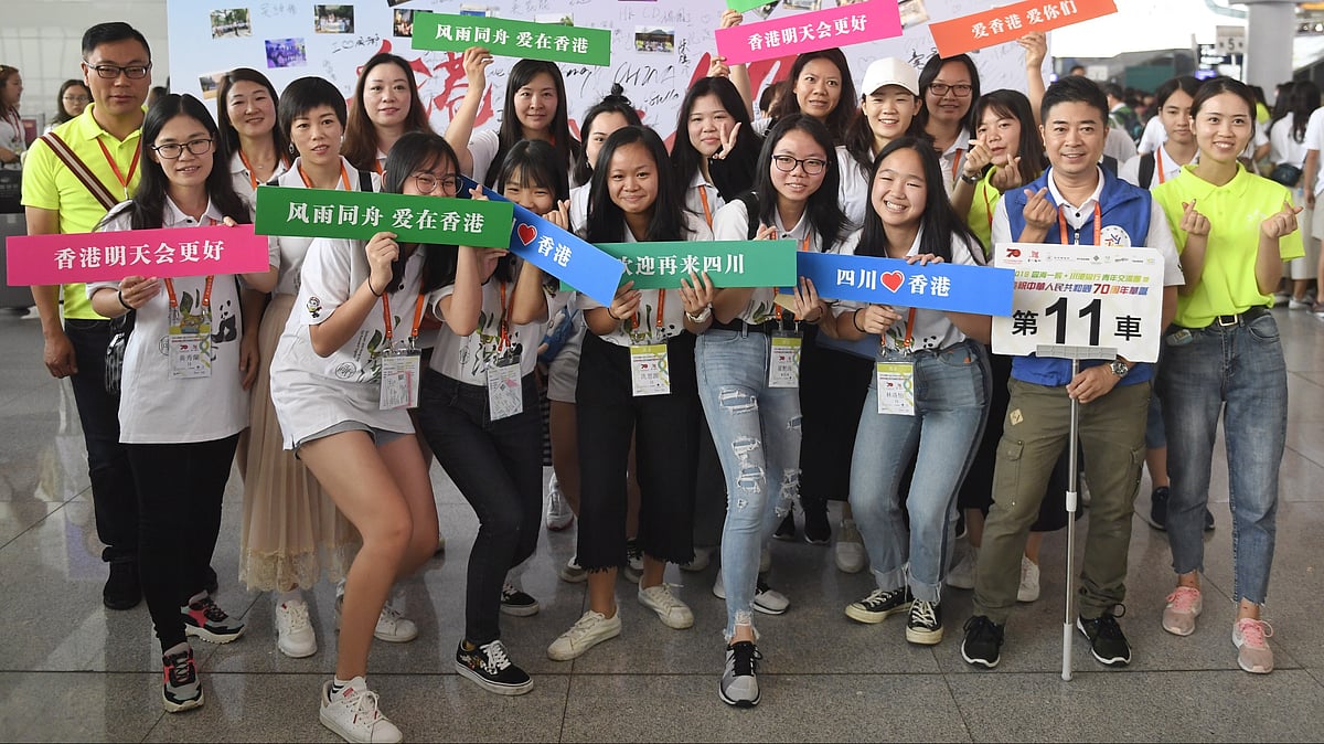 Young people from Hong Kong and volunteers pose for a group photo at Chengdu East Railway Station.