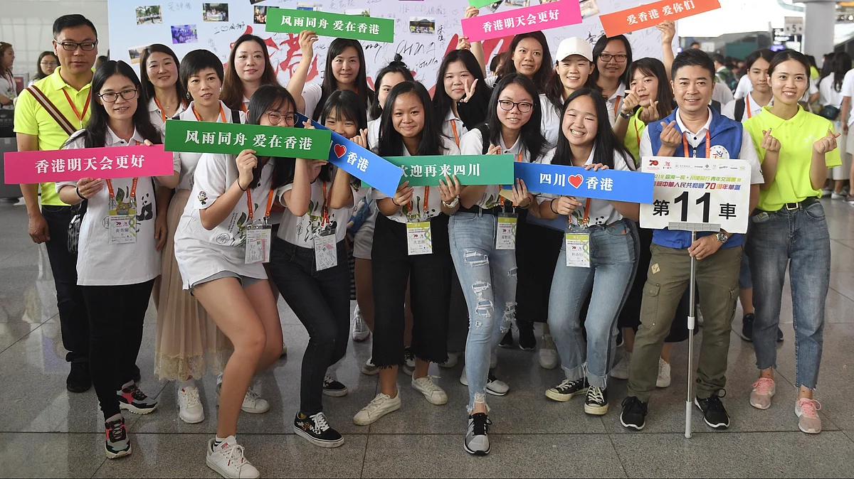 Young people from Hong Kong and volunteers pose for a group photo at Chengdu East Railway Station.