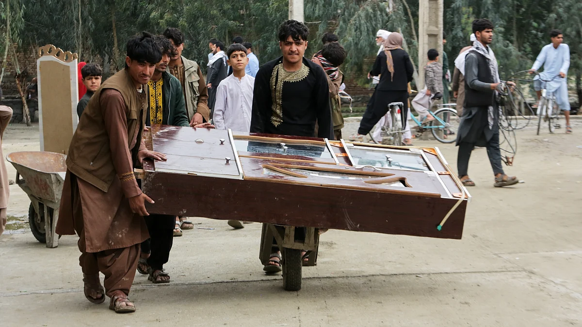Residents use a wheelbarrow to salvage belongings amid flood devastation in Afghanistan.