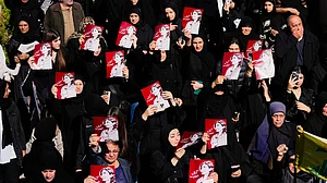 Mourners with images of Lebanese journalist Amal Khalil killed by Israel, at her funeral, 23 Apr