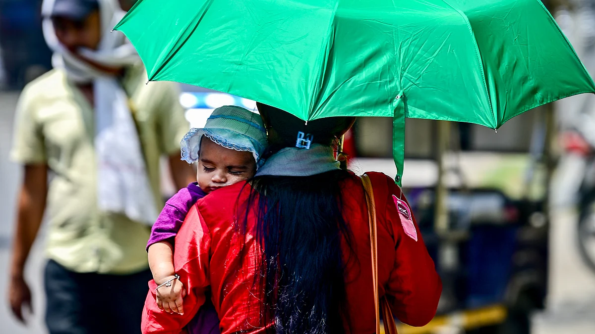 A woman shields her child from the scorching summer heat.