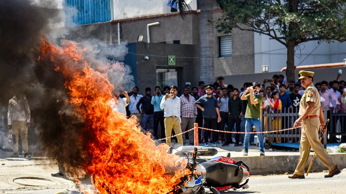A police bike set ablaze by factory workers during the Noida protests on 13 April