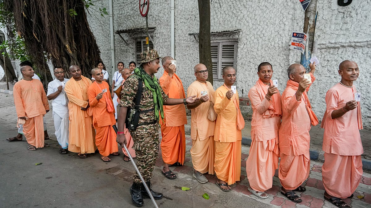 Iskcon monks display ID cards while queuing to vote during Phase-II of assembly polls in Kolkata.