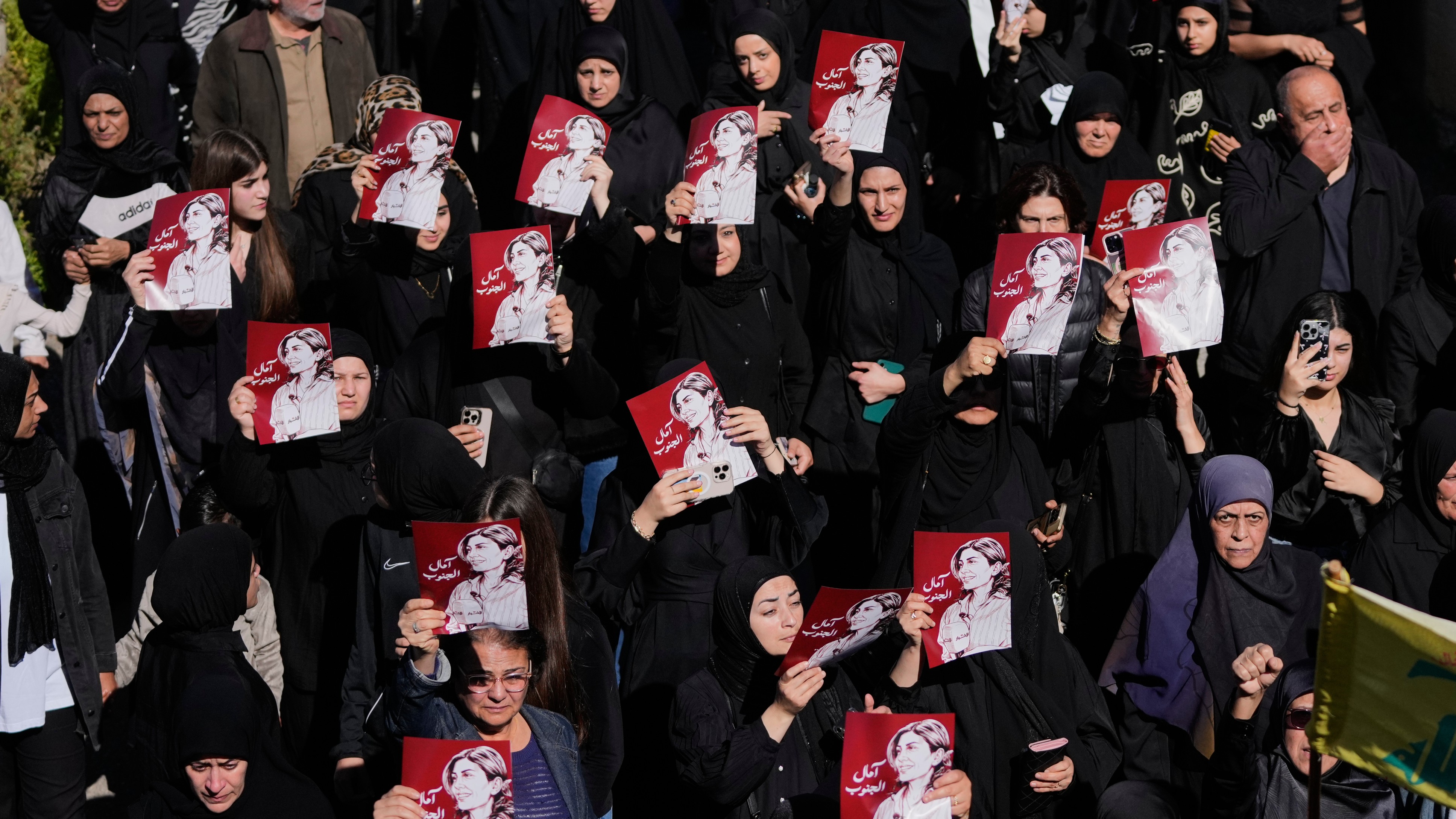 Mourners hold posters of slain journalist Amal Khalil during her funeral in Baysariyeh.
