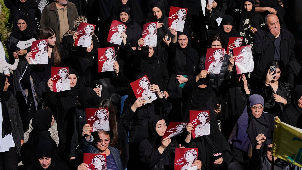 Mourners hold posters of slain journalist Amal Khalil during her funeral in Baysariyeh.