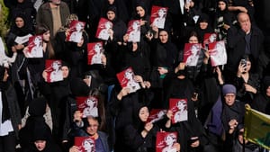 Mourners hold posters of slain journalist Amal Khalil during her funeral in Baysariyeh.