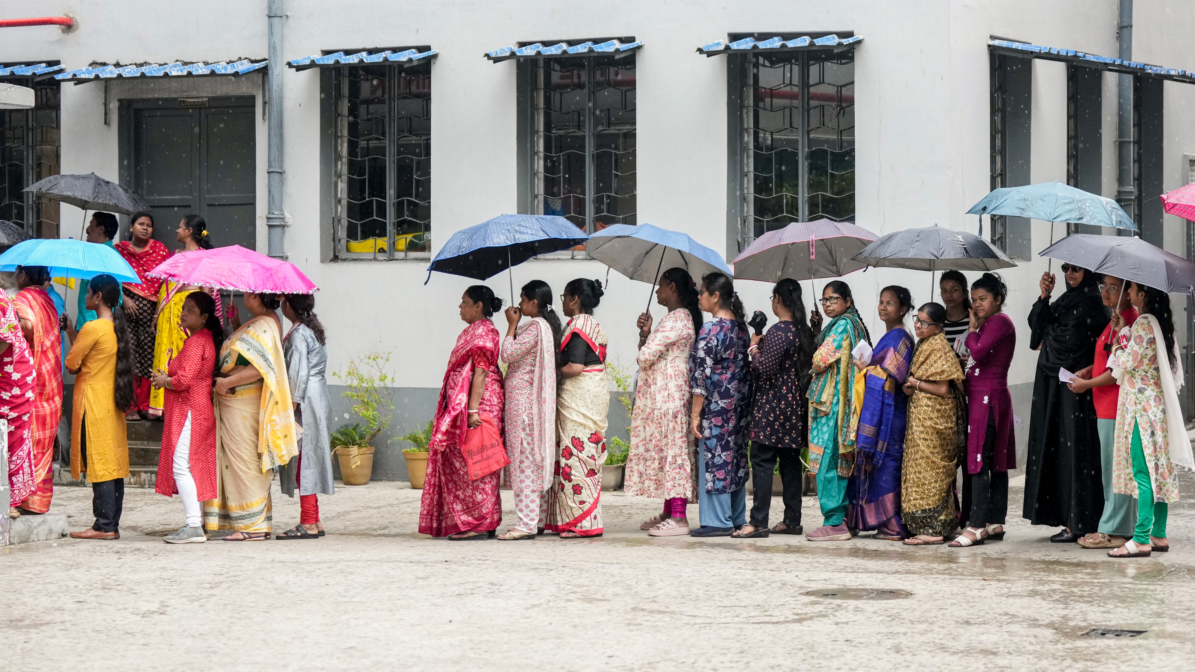 Voters queue in rain during Phase-II polling in Kolkata.