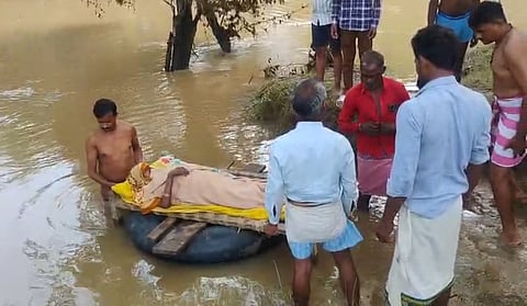 Injured woman carried on a cot over a tube to cross the flooded Son River