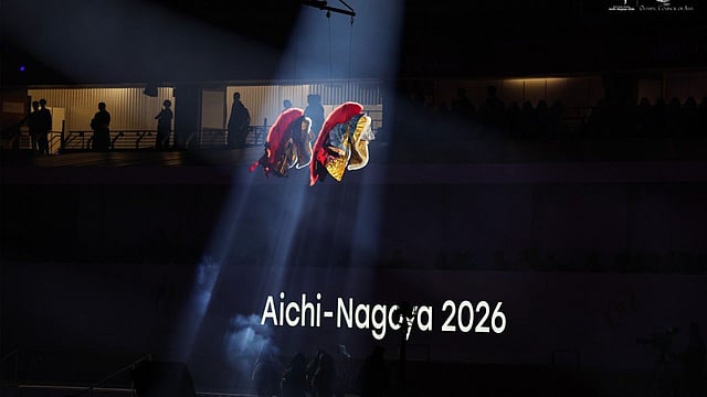 Two aerial performers float under a spotlight 