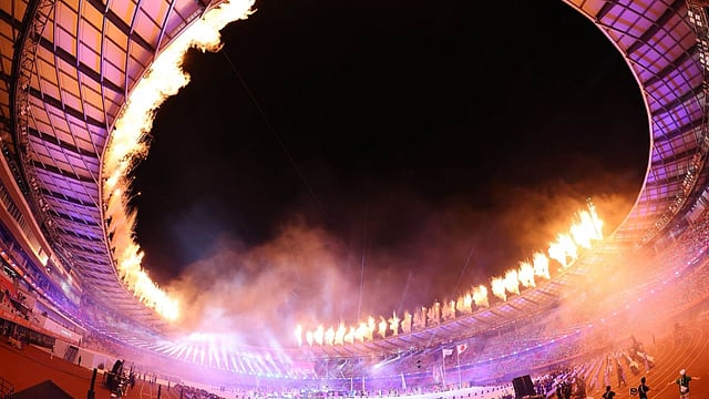 Sweeping wall of fireworks ignites around the entire circular rim of the stadium roof
