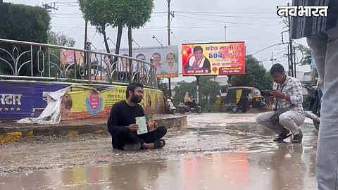 Rewa youth sits on road reading book during rain