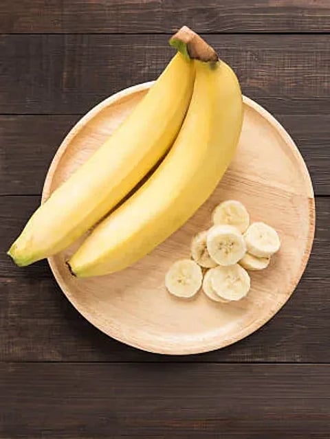 Bananas in a wooden dish on a wooden background. space for text.