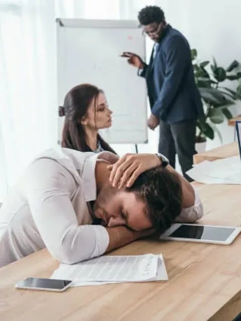 sleepy businesspeople having conversation at office