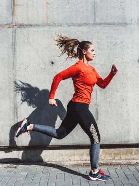 Woman in jogging outfit running outdoors.