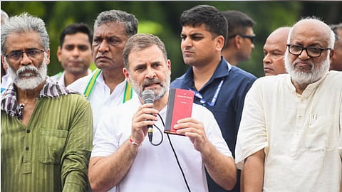 पटना में संविधान दिखाकर प्रदर्शन करते राहुल गांधी (pic credit; social media)