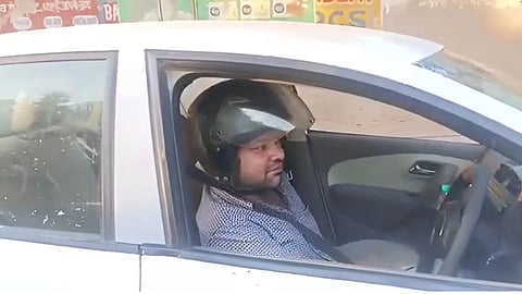 In Agra, Gulshan has turned a wrong traffic challan into a unique protest by wearing a helmet even while driving a car, highlighting flaws in the traffic system.