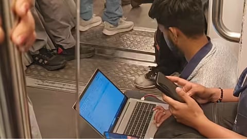A viral video shows a man working on his laptop while sitting on the floor of a crowded metro.