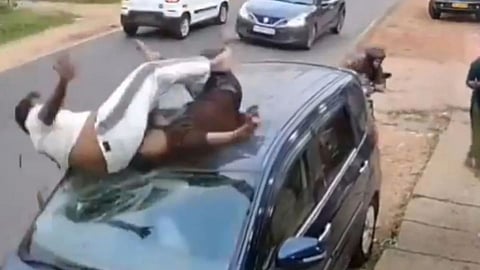 A viral CCTV video shows two men crashing onto the roof of a parked car after a shocking road accident.