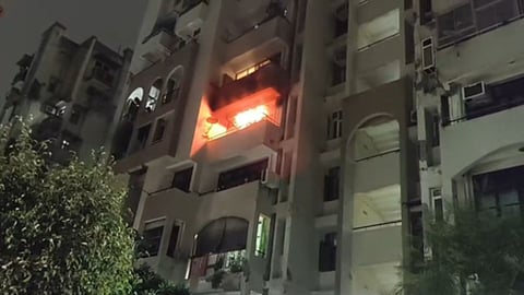 Flat engulfed in flames in Noida; elderly couple trapped on the fourth floor rescued safely by firefighters.