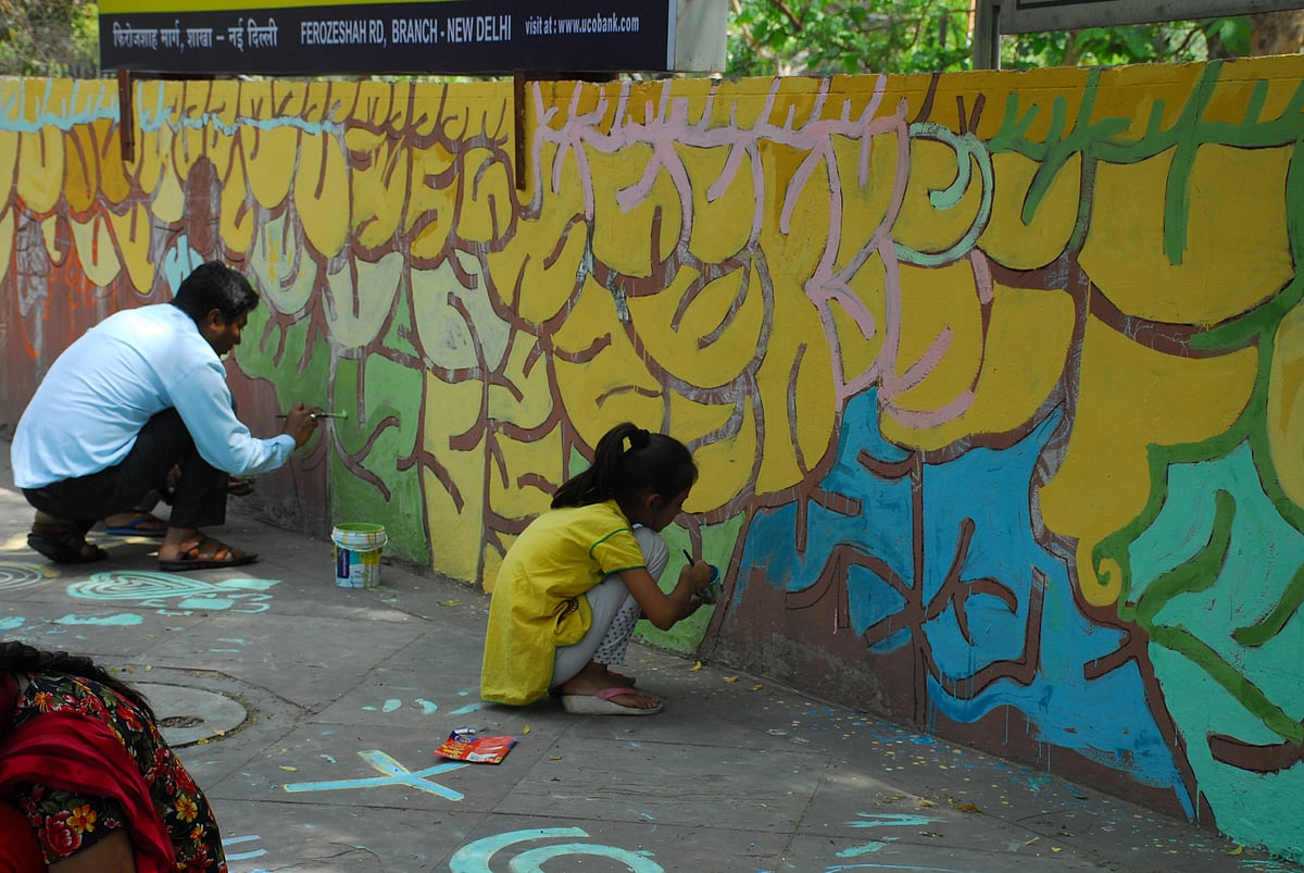 

दिल्ली की दीवारों को रंग से भरते कलाकार