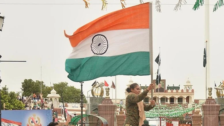 बाघा बार्डर पर बीएसएफ के सैनिक हाथों में भरतीय तिरंगा थामे हुए/ फोटो: Getty Images