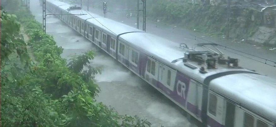 मुंबई में भारी बारिश के बाद सड़कों और रेलवे ट्रैक पर जमा हुआ पानी, 13 ट्रेनें रद्द, धीमी हुई लोकल की रफ्तार