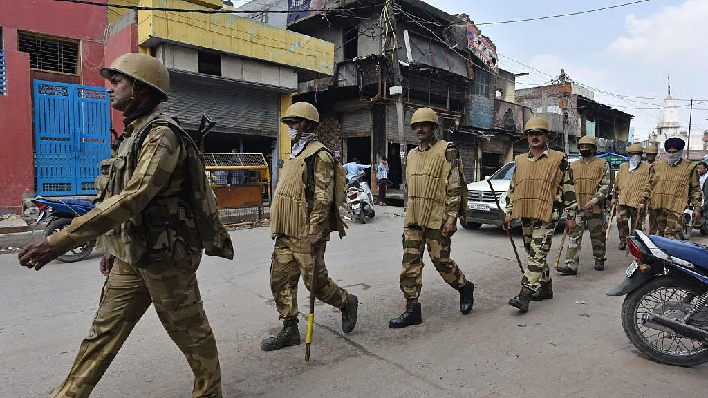 उत्तर पूर्वी दिल्ली में 2020 में हुए दंगों के बाद इलाके में गश्त करती पुलिस (फोटो : Getty Images)