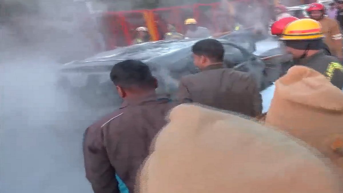 गाड़ियों में लगी आग पर काबू पाते दमकलकर्मी।