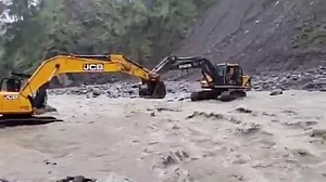 जम्मू-कश्मीर के रियासी में लोग JCB की मदद से भदौरा नाला पार करते दिखे, दो महीने से टूटा पड़ा है पुल