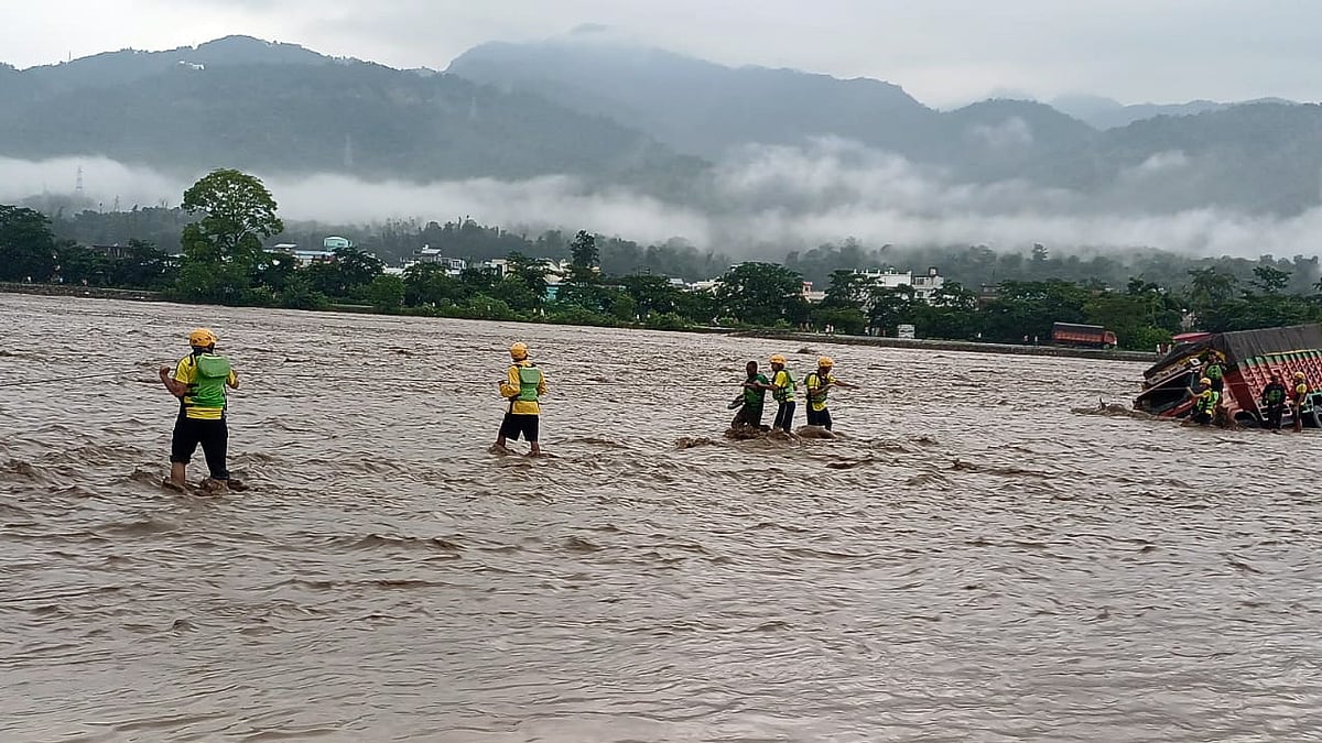 ऋषिकेश में भारी बारिश के कारण चंद्रभागा नदी के उफान पर होने के कारण एसडीआरएफ कर्मियों ने फंसे लोगों को बचाया