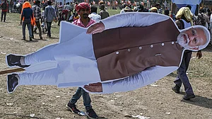 कोलकाता में एक चुनावी रैली के बाद पीएम नरेंद्र मोदी का कटआउट ले जाते लोग (फोटो: Getty Images)