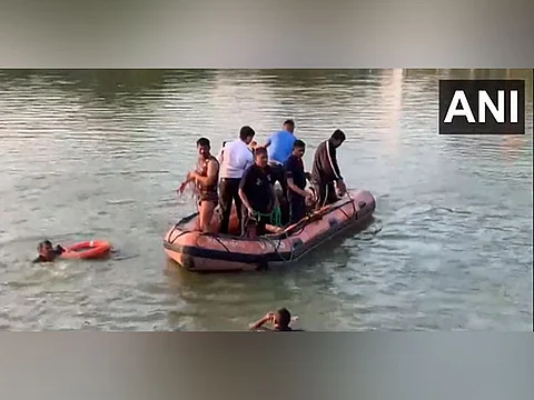 People gather during a rescue and search operation after a boat overturned in a lake, in Vadodara, Thursday, Jan. 18, 2024