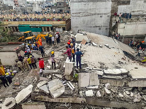 Officials and others during a rescue operation after a building collapse, in Surat district, Saturday, July 6, 2024.